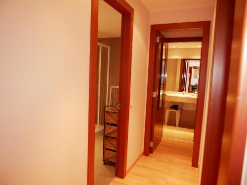 un couloir avec une porte menant à une salle de bains. dans l'établissement Solana-El Tarter, au Tarter
