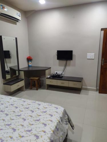 a bedroom with a bed and a desk and a tv at Guesthouse Sakina Colva in Colva