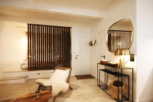 un salon avec une chaise et un miroir dans l'établissement Luxueux appartement, centre historique 50m du port et de la plage de la Ponche, à Saint-Tropez