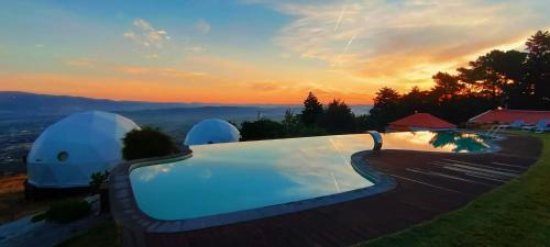 a luxury villa with a swimming pool at sunset at Natura Glamping in Alcongosta