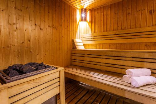 a sauna with two towels and rocks in it at Hotel Mursalitsa by HMG - Half board in Pamporovo