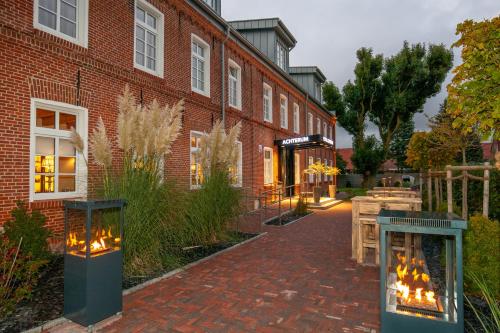 a brick building with a brick sidewalk in front of a building at Hotel Achterum Greetsiel in Greetsiel