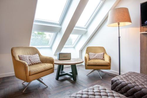 two chairs and a table in a room with skylights at Hotel Achterum Greetsiel in Greetsiel