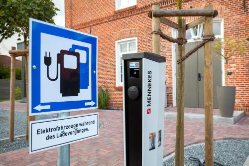 a sign next to a pay phone dispenser in front of a building at Hotel Achterum Greetsiel in Greetsiel