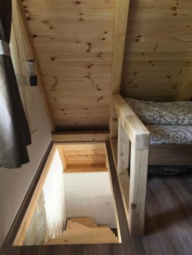 a bed in a room with wooden walls and ceilings at Planinska kuca ANDJELA 1 in Mitrovac