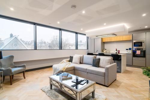 a living room with a couch and a table at Luxe Apartments, The Moorwell, Secure Parking, - 10mins Cardiff City Ctr in Cardiff