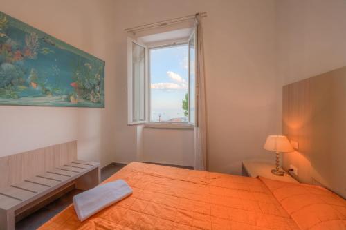 a bedroom with a large orange bed and a window at Affittacamere Da Flo in Monterosso al Mare