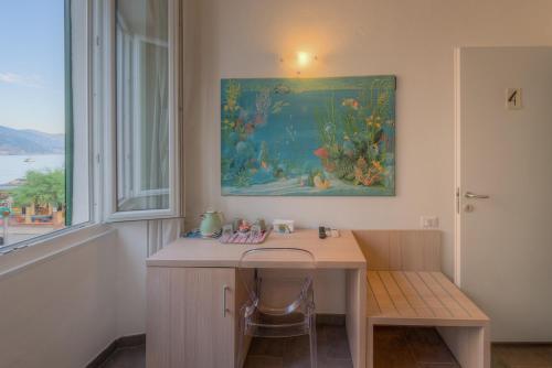 Habitación con escritorio y una pintura en la pared. en Affittacamere Da Flo, en Monterosso al Mare