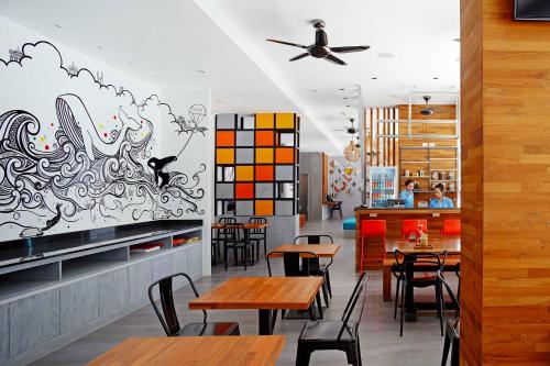 a restaurant with tables and chairs and a ceiling at The Crib Patong - SHA Certified in Patong Beach