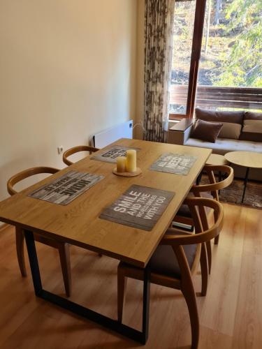 een houten eettafel met stoelen en een bank bij Родопски Рай in Pamporovo