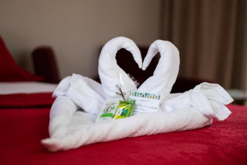 a pile of towels in the shape of a heart at Pousada Rosa Maria in Praia do Rosa