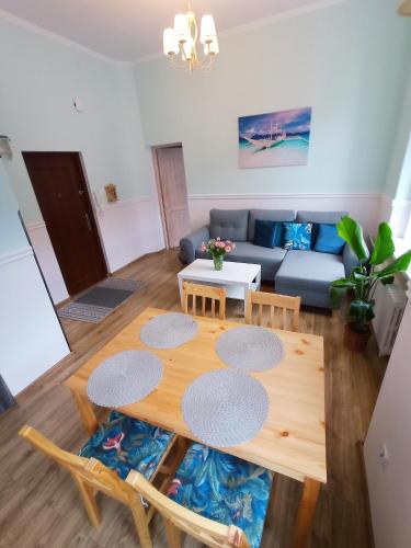 ein Wohnzimmer mit einem Tisch und einem Sofa in der Unterkunft Fiore in Duszniki-Zdrój