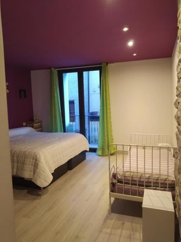 um quarto com uma cama e uma grande janela em Casa Díaz em El Pont de Suert
