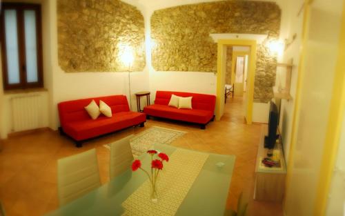 a living room with two red couches and a table at incantevole e storico appartamento in pieno centro in Taormina