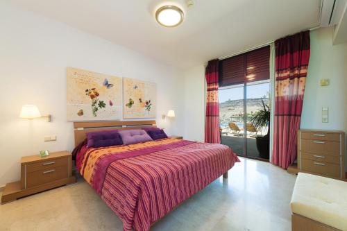a bedroom with a bed and a large window at Sunset Villa in La Playa de Tauro