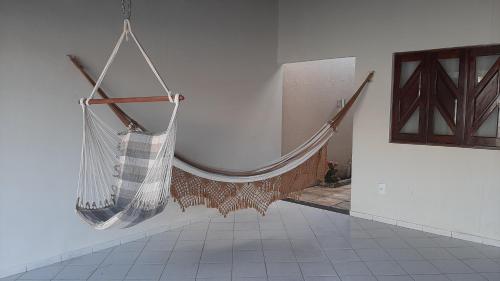 een hangmat hangend aan een muur in een kamer bij Casa em Natal Cond. Fechado com Piscina-03 Suítes in Natal