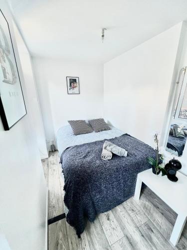 une chambre blanche avec un lit et une table dans l'établissement Studios meublés Brest Keruscun, à Brest