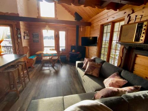 a living room with a couch and a table at Le petit chalet sur le lac in Sainte-Marguerite