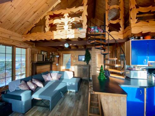 - un salon avec un canapé bleu dans une cabine dans l'établissement Le petit chalet sur le lac, à Sainte-Marguerite