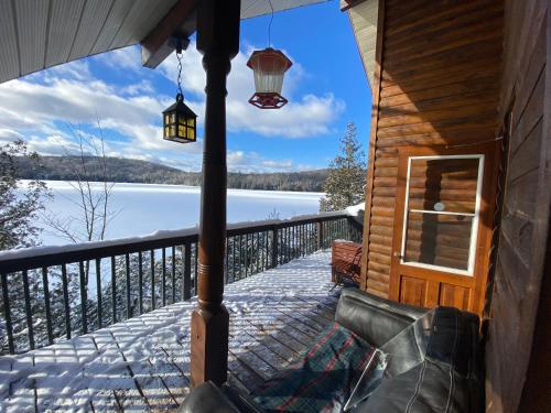 a porch of a cabin with a view of a lake at Le petit chalet sur le lac in Sainte-Marguerite