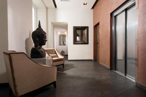 una habitación con una silla y una estatua en ella en Rome Times Hotel, en Roma