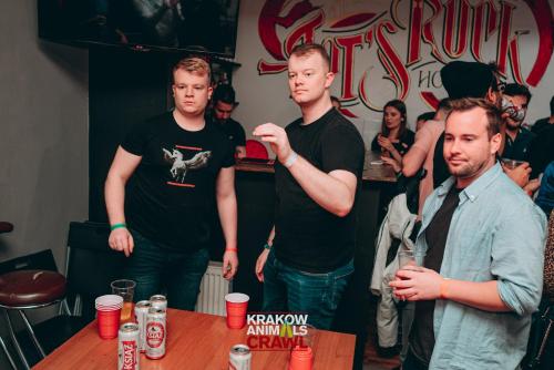 un grupo de hombres parados alrededor de una mesa en Let's Rock Party Hostel, en Cracovia