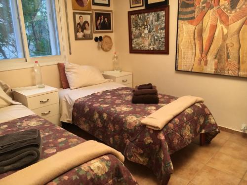 a bedroom with two beds and pictures on the wall at Dorraine's Jerusalem Bed & Breakfast in Jerusalem