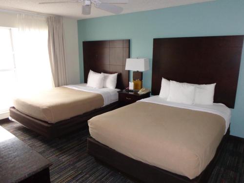 A bed or beds in a room at SureStay Plus by Best Western Orlando Lake Buena Vista