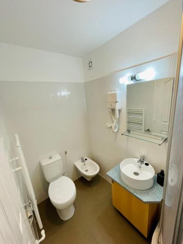 a white bathroom with a toilet and a sink at Casa Benke Ház in Covasna