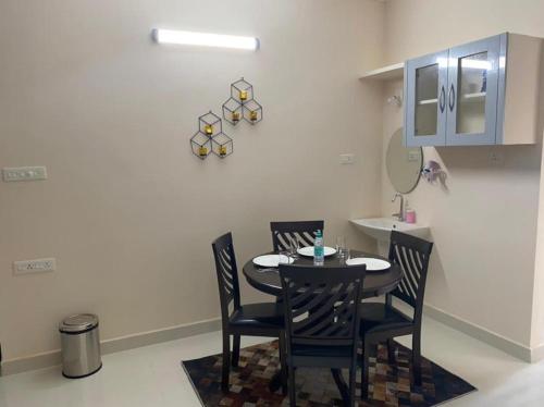 - une salle à manger avec une table et deux chaises dans l'établissement OM SRINIVASA - TRULY HOMESTAY, à Tirupati