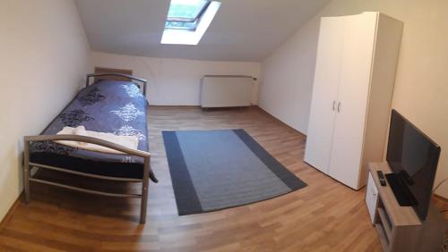 a small room with a bed and a tv at Ferienwohnung in Erftstadt in Erftstadt