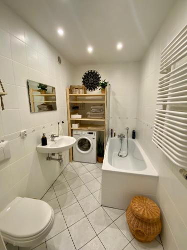 a bathroom with a sink and a tub and a toilet at mieszkanko_karkonoska in Jelenia Góra