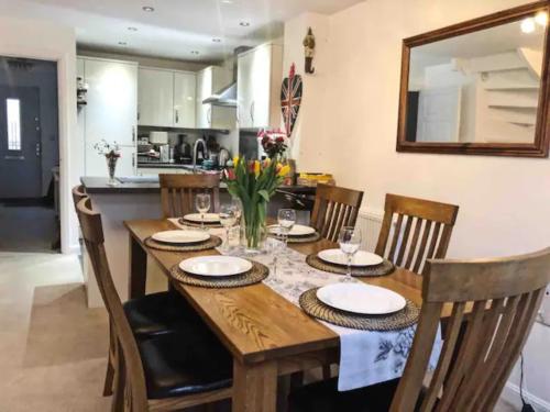 a dining room table with chairs and a kitchen at 4 bedroom house in seaside town in Littlehampton