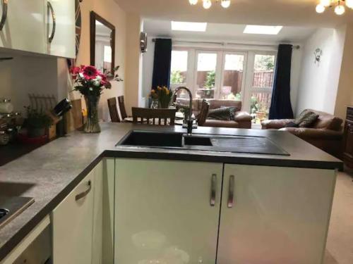 a kitchen with a sink and a living room at 4 bedroom house in seaside town in Littlehampton