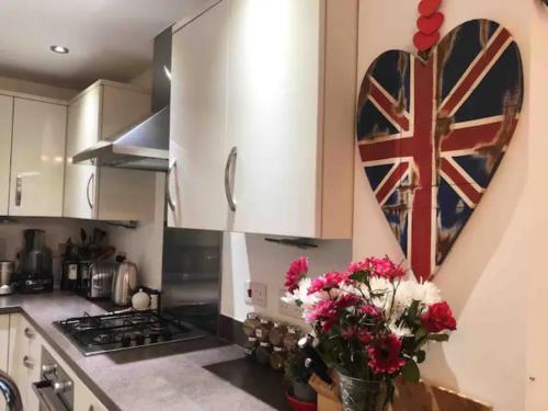 a kitchen with a heart with a flag on the wall at 4 bedroom house in seaside town in Littlehampton