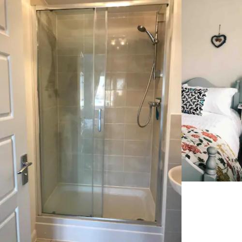 a shower with a glass door in a bathroom at 4 bedroom house in seaside town in Littlehampton