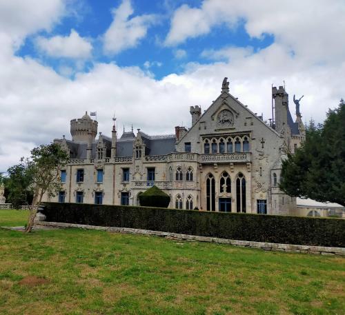 an old castle with a grass field in front of it at L'éléphant Blanc de ConcarnOLoc in Concarneau