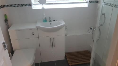 Un baño blanco con lavabo e inodoro. en Sundown 127 Sandown Bay Holiday Centre Generous Ferry Saving!, en Sandown