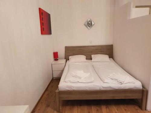 Cette petite chambre comprend un lit avec des draps blancs. dans l'établissement Vibrant Red Apartment I contactless Check-In, à Vienne