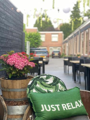 ajust relax pillow sitting on a bench next to flowers at Hotel 't Peperhuys in Kaatsheuvel