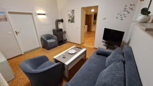 a living room with a blue couch and chairs at Ferienwohnung Bonese in Bonese