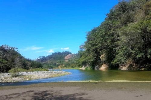 a river with trees on the side of it at CASITA HOGAREÑA JARABACOA (independent entrance) in Jarabacoa
