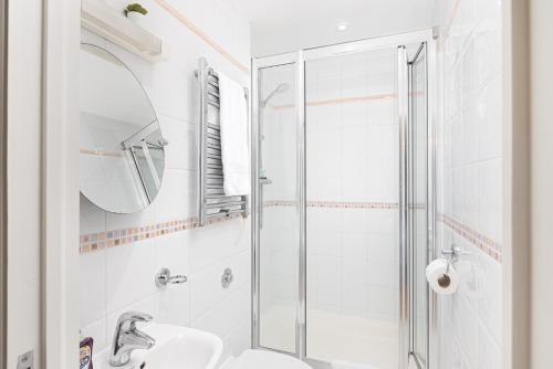 a white bathroom with a shower and a sink at Beautiful 2Bed 2Bath Apartment 4Mins to Train Station with WiFi and Free Parking in New Barnet