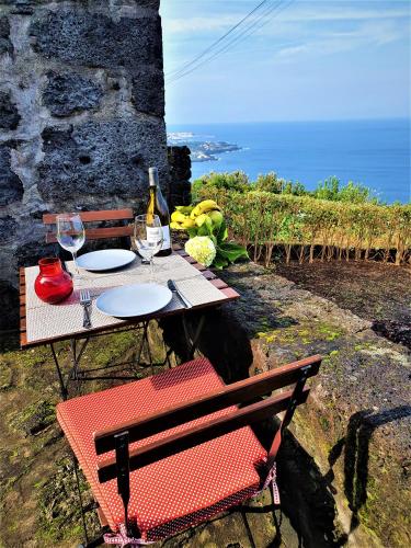 a picnic table with a bottle of wine and glasses at Casa do Arcanjo in São Roque do Pico