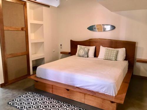a bedroom with a bed with white sheets and pillows at La Buena Vida Cabinas in Playa Grande