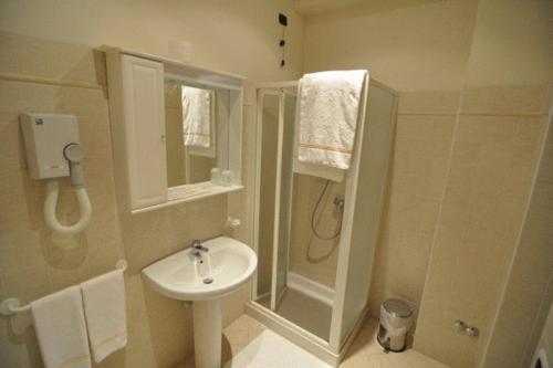 a white bathroom with a sink and a shower at Albergo Villa San Giuseppe in Noceto