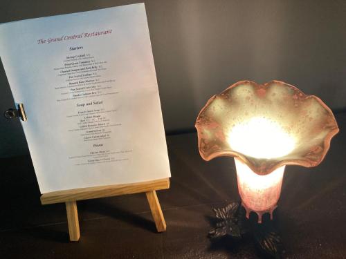 ein Menü und ein Licht auf einem Tisch mit einer Lampe in der Unterkunft Grand Central Hotel in Eureka Springs