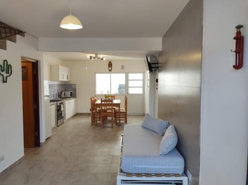 sala de estar y cocina con sofá y mesa en Los Nardos Duplex en San Salvador de Jujuy