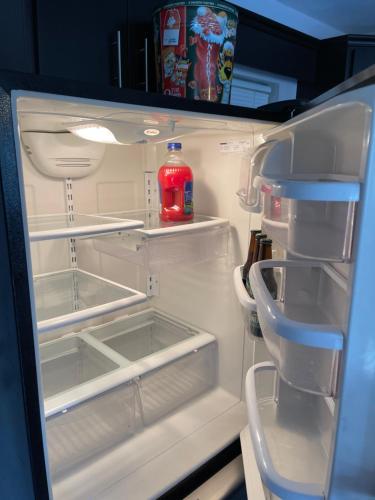 an open refrigerator with a bottle of drink in it at Otay 2 bedroom condo in Tijuana