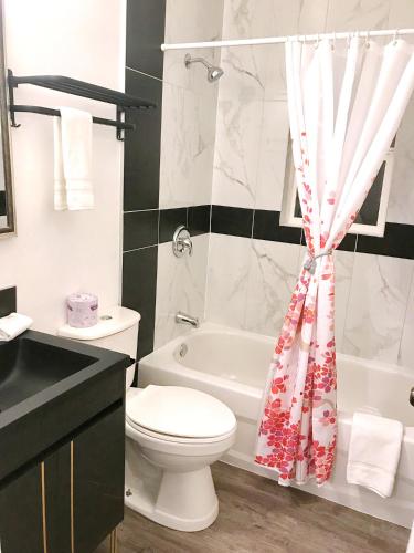 a bathroom with a toilet and a shower curtain at Duncan Motel in Duncan
